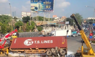 Xe container bất ngờ lật ở vòng xoay, sơn đổ trắng mặt đường lúc rạng sáng