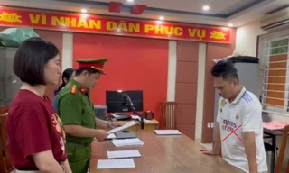 Nguyễn Thành Long (áo trắng) tại cơ quan công an.