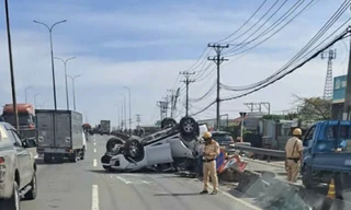 Ô tô chở 4 người lật ngửa trên dốc cầu Bình Thuận