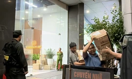 Cảnh sát vận chuyển nhiều thùng niêm phong ra khỏi tòa nhà có trụ sở công ty Shark Bình