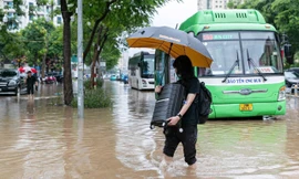 Người dân xắn quần bì bõm vác vali, dắt xe vượt 'biển nước' trên đường Võ Chí Công