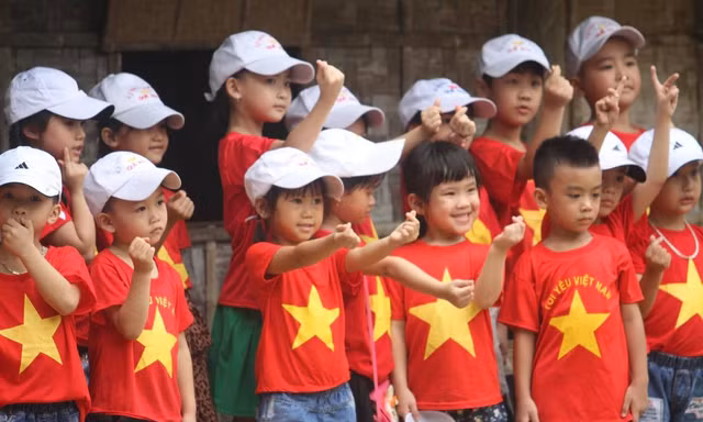Trẻ em mặc áo đỏ sao vàng thả tim tại làng Sen quê Bác