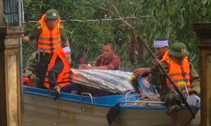 Công an dùng xuồng máy vượt lũ đưa thi thể cụ bà đi an táng