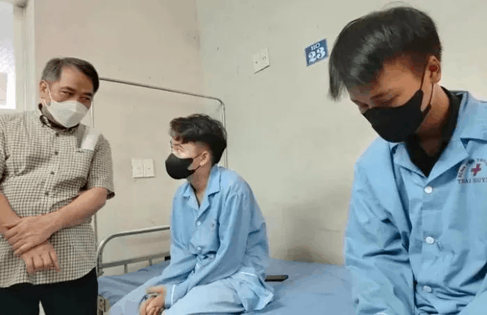 Bác sỹ Nguyễn Trung Cấp (bìa trái) thăm hỏi các em học sinh đang điều trị tại Bệnh viện trung ương Thái Nguyên.