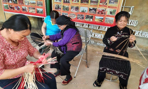 Cụ Vành (đeo kính ngồi giữa) truyền nghề đan lát cho thế hệ sau 