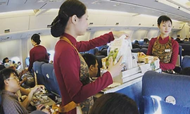 Nữ tiếp viên VNA đang phục vụ hành khách trên máy bay - Ảnh minh hoạ