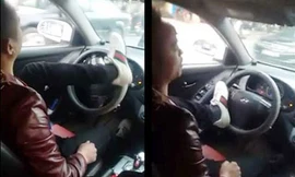 Tài xế lái xe bằng chân chạy qua nhiều tuyến phố ở Hà Nội. Ảnh cắt từ clip