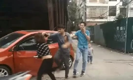 Người chồng hùng hổ lao vào đánh vợ bất chấp sự can ngăn của người đi đường. Ảnh cắt từ clip