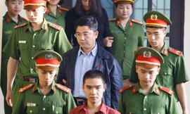 Bị cáo Nguyễn Văn Dương (giữa) được cơ quan chức năng dẫn giải ra tòa