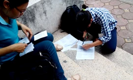 Thí sinh in sao tài liệu rồi cắt, dán, đóng gim bên ngoài cửa hàng photo. Ảnh: Minh Minh