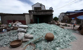 Mảnh kính vỡ được gia đình anh Phạm Ngọc Hân, chủ một lò thổi thủy tinh ở làng Xối Trì chất thành đống lớn giữa sân nhà