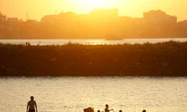 Dưới chân cầu Vĩnh Tuy phía tả ngạn sông Hồng, nhiều bãi bồi tự nhiên thoai thoải phủ cỏ xanh mướt đang trở thành những bãi tắm hấp dẫn người dân đổ về trong những ngày hè nóng nực. 