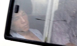 Tuấn bị cảnh sát áp giải. Ảnh: Quốc Thắng