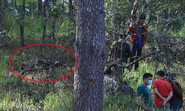 Cảnh sát khám nghiệm hiện trường nơi thi thể nạn nhân (khoanh tròn đỏ) cháy đen