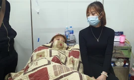 Một nạn nhân (trái) được người thân chăm sóc ở bệnh viện. Ảnh: Zing