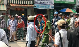 Thành (áo xanh đậm) bị đưa về trụ sở