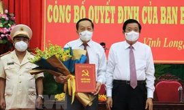 Bí thư Tỉnh ủy Vĩnh Long Bùi Văn Nghiêm trao Quyết định và tặng hoa chúc mừng ông Nguyễn Thành Thế. (Ảnh: Phạm Minh Tuấn/TTXVN)
