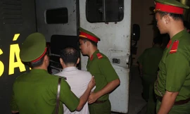 Cảnh sát áp giải bị cáo Lương Văn Thảo lên xe thùng.