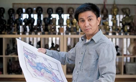 Anh Trần Đình Thắng cầm trên tay một tấm bản đồ tại nhà riêng ở West Hartford, Connecticut