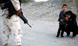 Người mẹ Guatemala cầu xin lính cho cô được vào Mỹ. Ảnh: Reuters