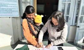 Đồng bào điểm chỉ và nộp bản photo sổ hộ khẩu để nhận quà