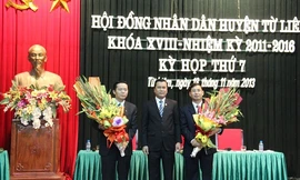 Bí thư Huyện ủy Từ Liêm Lê Văn Thư tặng hoa chúc mừng tân Chủ tịch huyện Nguyễn Văn Tứ (bên phải) và Phó Chủ tịch huyện Trần Thanh Long