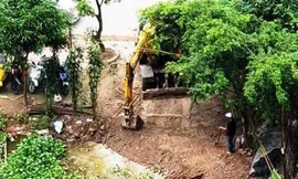 Máy xúc đang được huy động để xúc đất lấn hồ Ngòi
