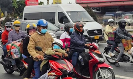 Người dân lỉnh kỉnh đồ đạc, trẻ em vật vã trên xe gắn máy về quê ăn Tết