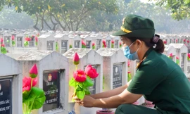 Nữ chiến sỹ thay hoa mộ liệt sỹ