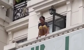 Hình ảnh cô gái ngồi trên lan can tầng ba ngôi nhà ở TP.HCM. Ảnh: VietNamNet