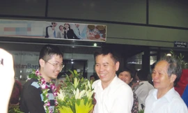Thày Nguyễn Đức Hoàng chúc mừng Đậu Hải Đăng (trái) tại sân bay Nội Bài. Người ngoài cùng bên phải là bố của Đăng Ảnh: Quý Hiên
