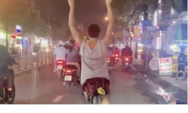 Người đàn ông lái xe đạp buông hai tay trên phố ở TPHCM