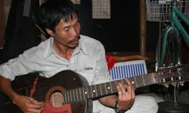 Người đàn ông nghèo với cây đàn guitar giúp dân xóm trọ ổ chuột vơi nhọc nhằn sau ngày làm việc. Ảnh: V.T.