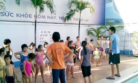 Mỹ Phước (ngòai trái) đang hướng dẫn trẻ khuyết tật trước khi xuống nước