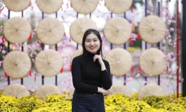 Các bạn trẻ chụp ảnh lưu niệm tại mô hình nón quai thao ở đường hoa Tết. Ảnh: Nguyễn Thắng.