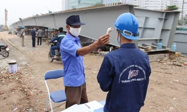 Công nhân trước khi vào công trường giao thông Hà Nội được đo thân nhiệt. Ảnh: Trọng Đảng