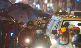 Nhiều người chôn chân, co ro đứng dưới vì ùn tắc trên đường chiều tối nay. Ảnh: Mạnh Thắng