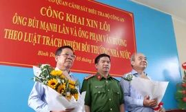Thượng tá Đặng Trọng Cường tặng hoa cho ông Lân (trái) và Hướng (phải) tại buổi công khai xin lỗi. Ảnh: Tân Châu
