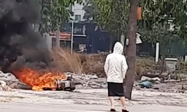 Cô gái đứng nhìn xe cháy. Ảnh: CTV