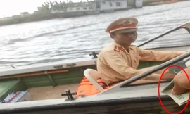 CSGT đường thủy trạm Khánh Tiên (Ninh Bình) ngồi trên cano nhận tiền từ chủ tàu.