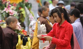 Nhiều bạn trẻ thành kính bưng gáo nước thơm bằng cả 2 tay tắm cho Phật