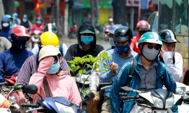 Người dân trùm kín, vất vả di chuyển dưới cái nắng gắt đầu hè