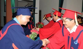 Phó TBT Báo Tiền Phong Vũ Tiến và lãnh đạo Viện ĐH Mở trao bằng cử nhân và hoa cho các học viên tốt nghiệp. Ảnh: Tuấn Nguyễn