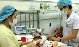 Nhân viên y tế điều trị cho trẻ mắc bệnh mùa Hè. (Ảnh: TTXVN)