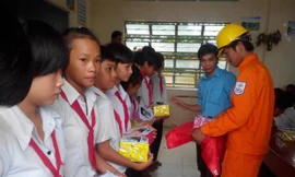 Nhân viên công ty Điện lực Kiên Giang tặng quà lồng ghép tuyên truyền tiết kiệm điện cho học sinh