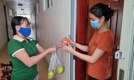 Chị Châm Anh (phải) mua trái cây từ “siêu thị” hàng xóm. Ảnh: Thanh Trần 