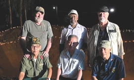 Ông Thụy - bên trái hàng trước - cùng những cựu binh Mỹ bên hố chôn liệt sĩ đồi Xuân Sơn Ảnh: NVCC 