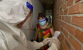 Nhân viên y tế phát thuốc điều trị tại nhà cho F0 