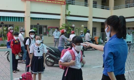 Giáo viên trường Tiểu học An Lạc 1, quận Bình Tân, TPHCM đo thân nhiệt học sinh trước khi vào trường