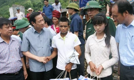 Bộ trưởng Đào Ngọc Dung trao quà và động viên anh Lò Văn Cu, cháu Quàng Thị Xuân ở xã Nậm Păm mất người thân trong trận lũ dữ